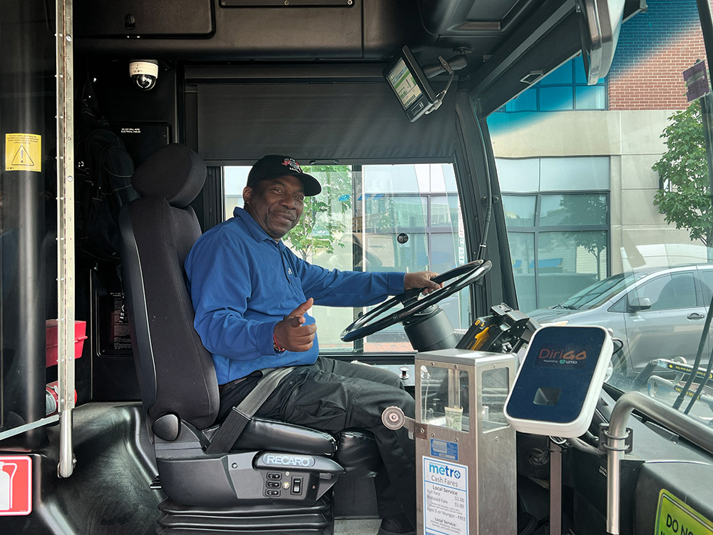 bus driver sitting in seat with bus door open