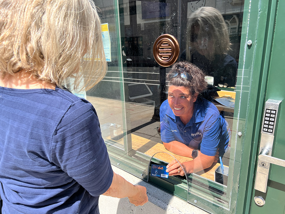 person being helped at the customer service window of the main transit hub